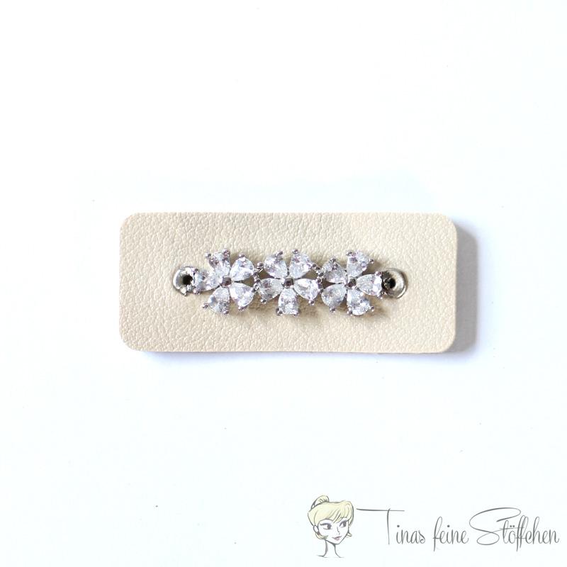 Beautiful light beige imitation leather patch with three zirconia flowers set in pavé